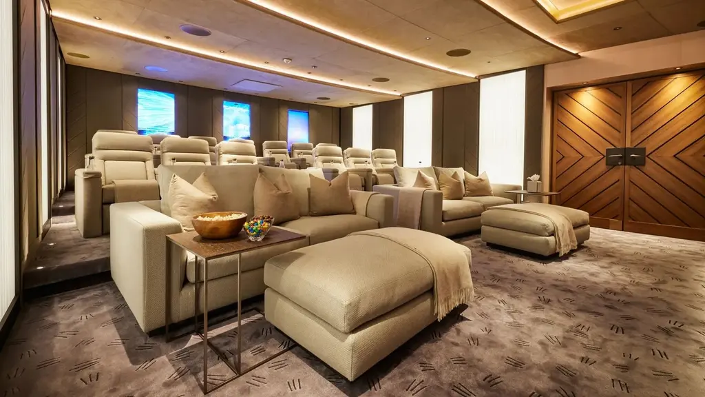 Cinema with tiered reclining seats and deep sofas in beige