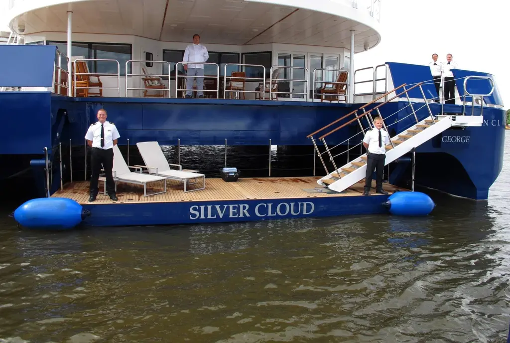 The stern of Silver Cloud with crew on a floating platform between the hulls and steps up to the aft deck
