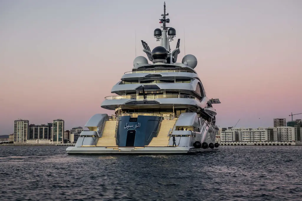 Al Lusail from astern at dusk, with twin staircases and her name in Arabic on the transom