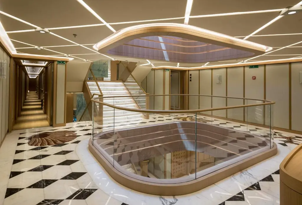 Lobby with a black-and-white marble floor around a glass-railed opening of the central atrium