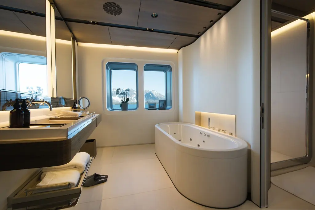 A bathroom with a freestanding tub, a vanity and two portholes