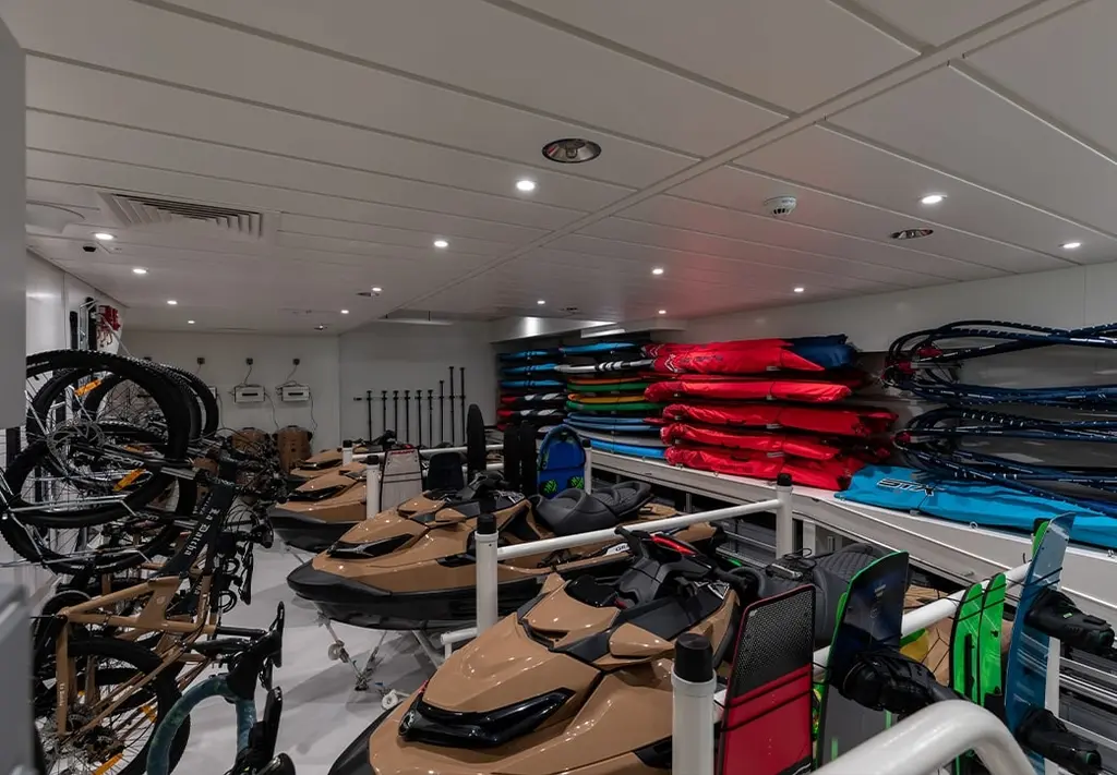 Toy store below deck with jet skis, bicycles and stacked paddleboards and kayaks
