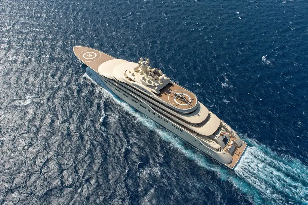 Overhead view of Dilbar underway, showing the bow helipad and the helicopter on the upper-deck helipad