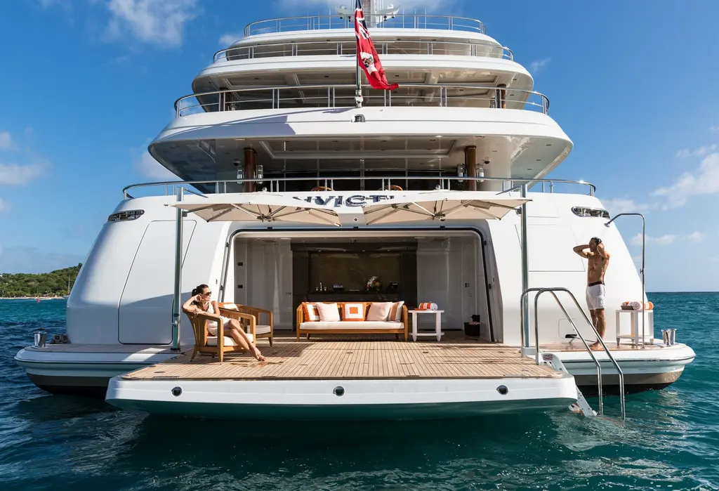 Stern of Invictus with the beach platform lowered and a lounge opening onto it