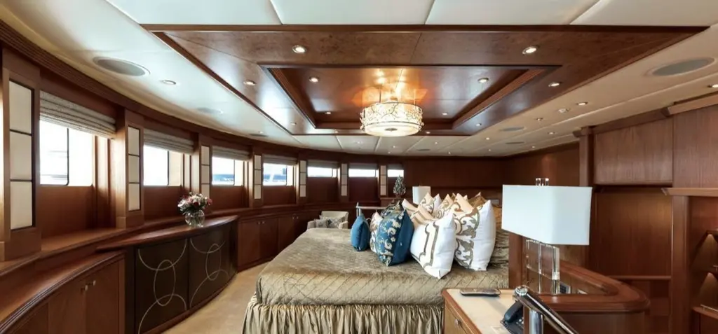 Full-beam master suite with a large bed, wood panelling and a row of windows along the side