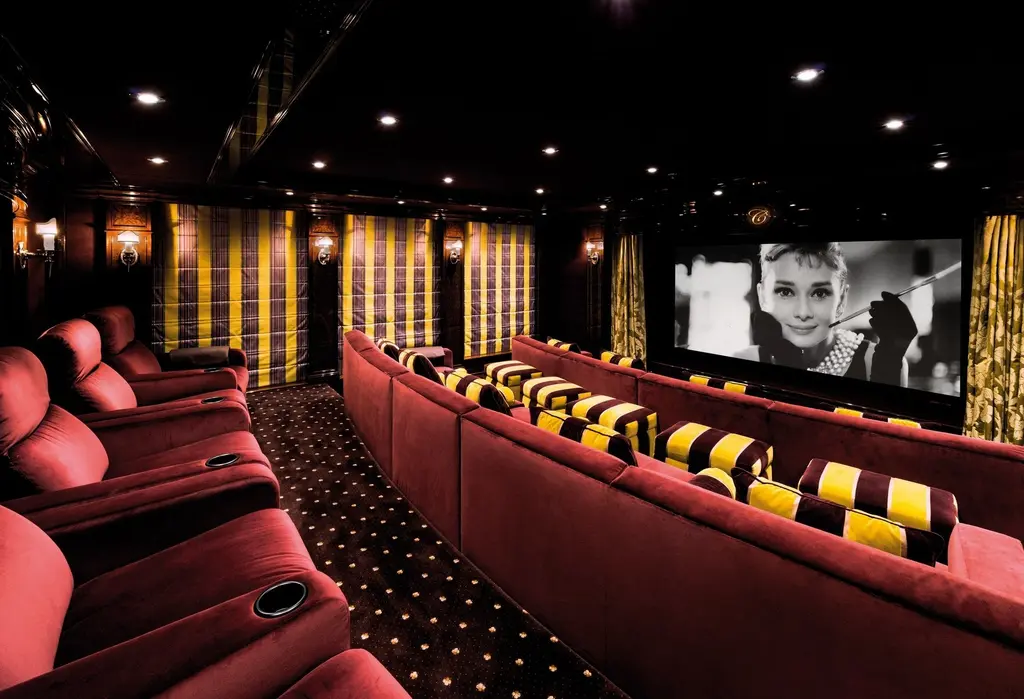 Cinema with tiered red seating and a large screen