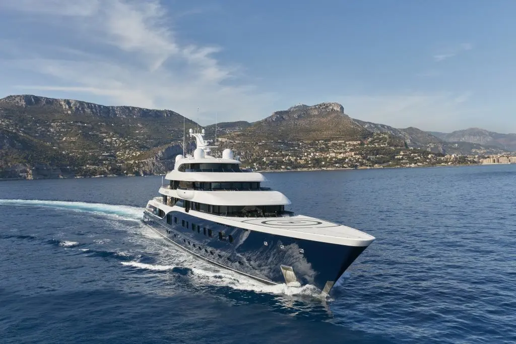 Symphony underway towards the camera along a mountainous coastline