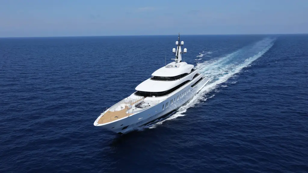 Aerial view of IJE under way on deep blue sea, the teak foredeck and wake trailing behind