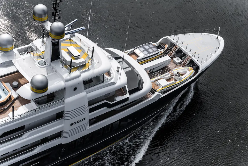 Close aerial view of Scout's foredeck with tenders stowed in the bay behind the raised helideck at the bow, the yacht's name on the superstructure and the radar domes on the mast