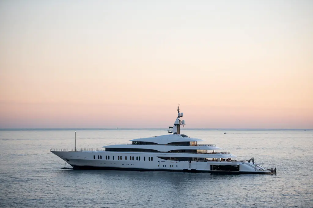IJE in profile on calm water at dusk under a pink and peach sky