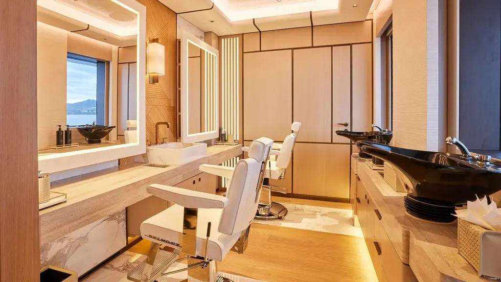Hair salon with two white styling chairs, backlit mirrors and wash basins