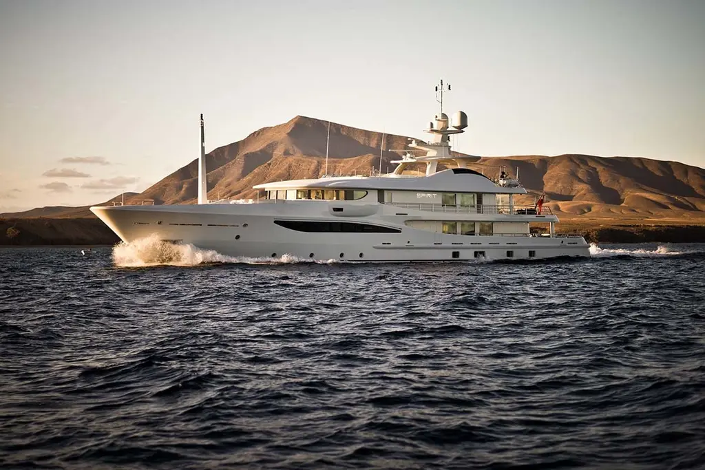 Spirit underway at dusk in front of a bare brown hillside