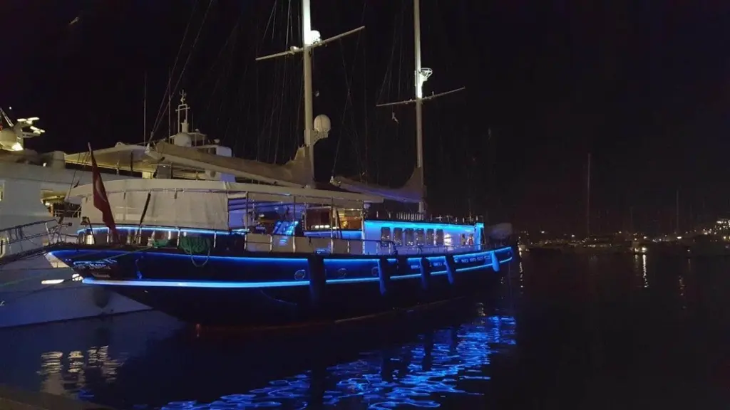 Sea Dream moored at night with blue lights along the hull