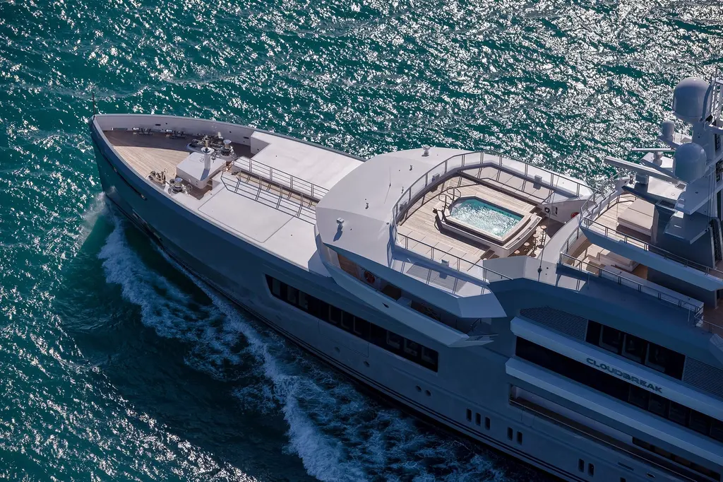 Aerial close-up of Cloudbreak's foredeck and stepped upper decks as she moves through green water