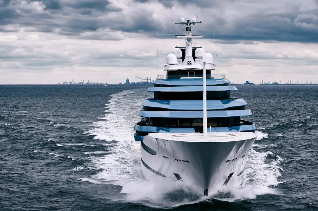 Head-on view of the yacht at speed, showing the blue-tinted superstructure decks