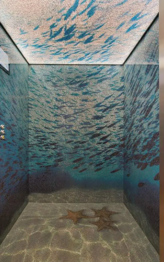 Inside a lift decorated with a mural of a fish shoal and starfish on a sand-effect floor