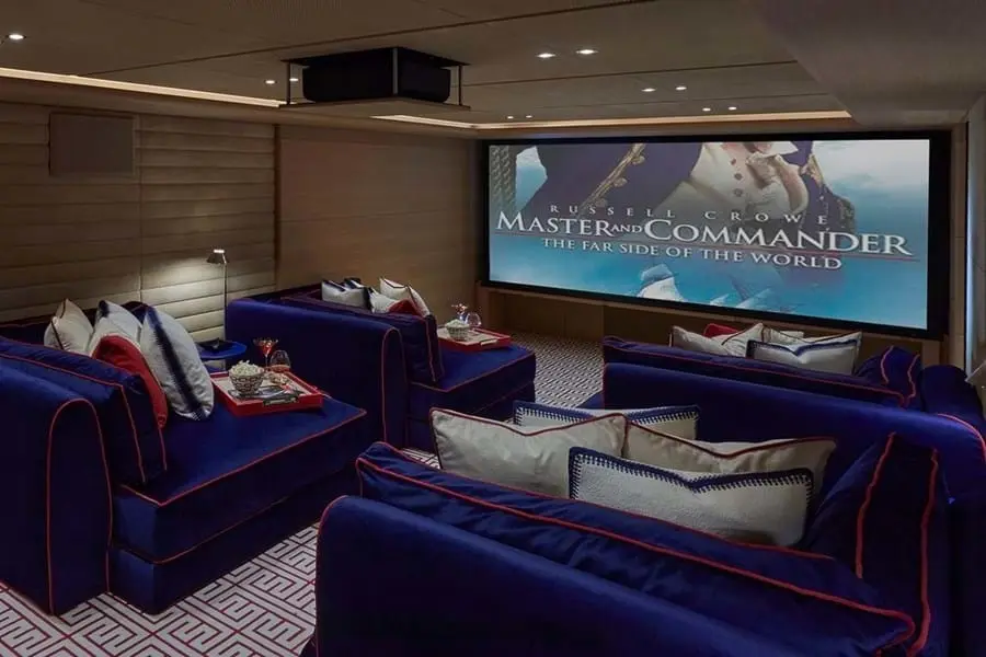 Cinema with deep blue sofas and a large screen