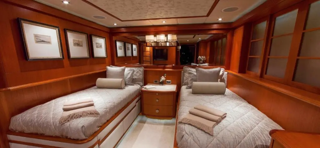 Twin cabin with two single beds and framed pictures above