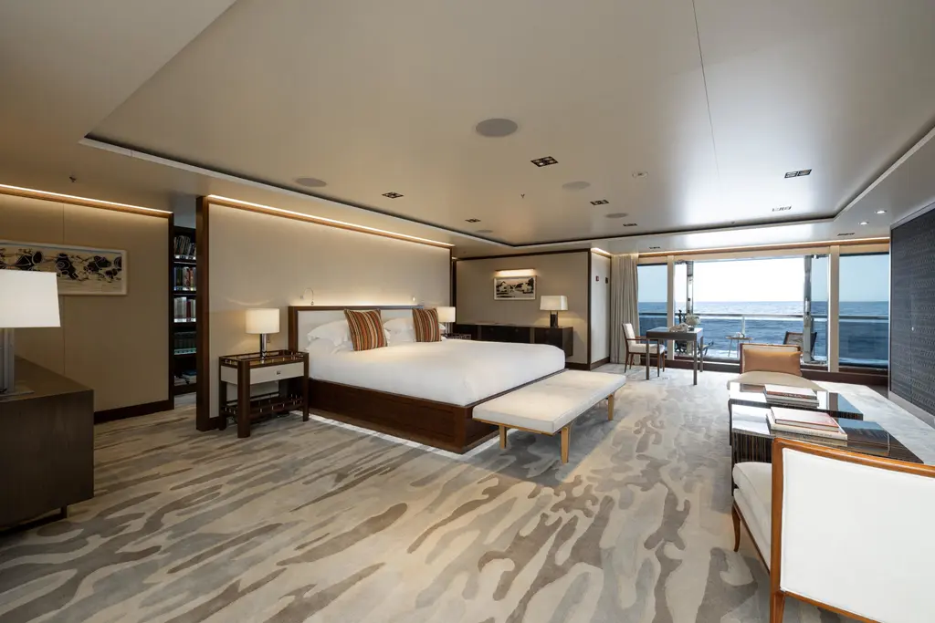Owner's stateroom with a wide bed, a sofa and windows to the sea
