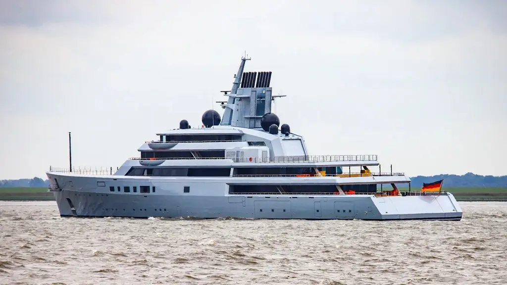 Dragonfly seen from the stern quarter on a river, showing the aft decks and the mast with radar domes