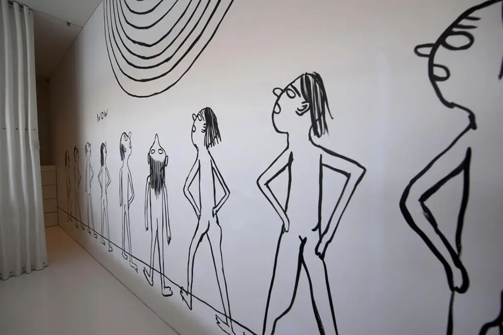 Black line drawing of a row of naked cartoon figures and the word WOW painted directly on a white cabin wall