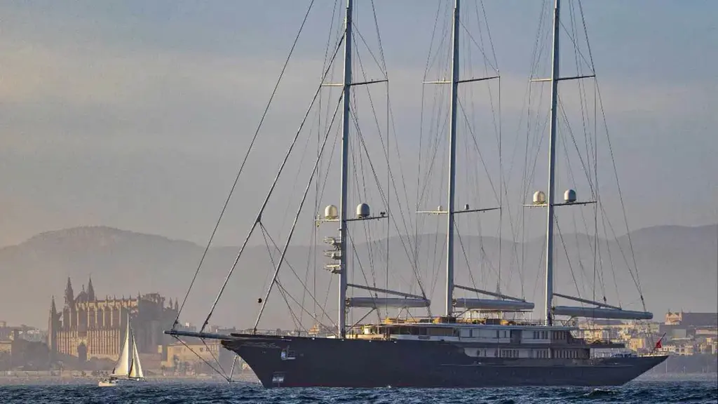 Koru at anchor in hazy light with Palma Cathedral and the Mallorca hills behind