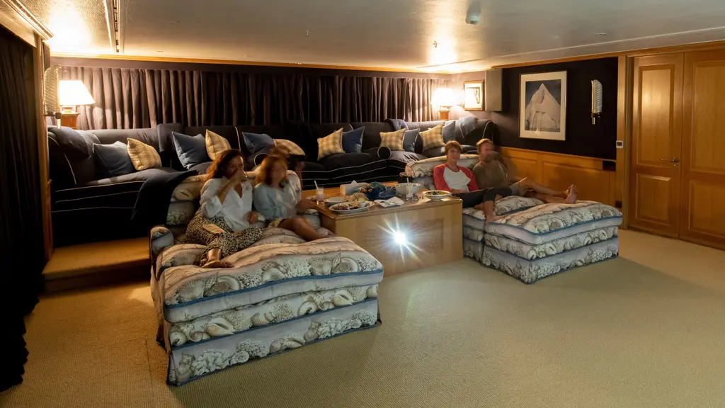 Guests on deep sofas and floor cushions in a darkened cinema room