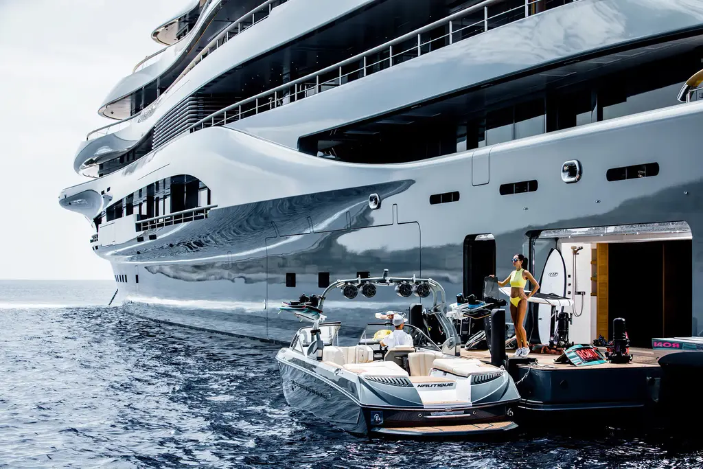 A tender alongside an open side door of the hull